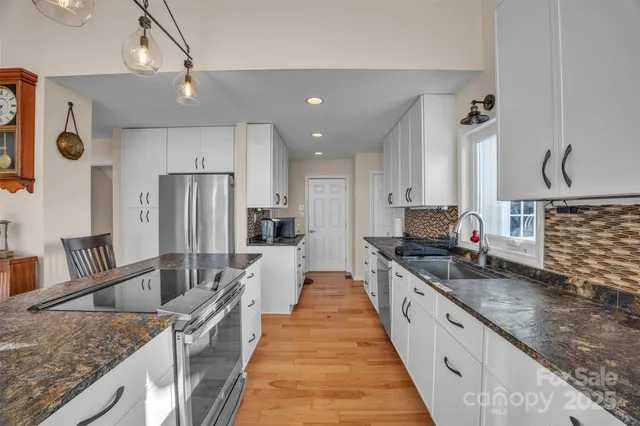 a large kitchen with granite countertop a large counter top appliances and cabinets