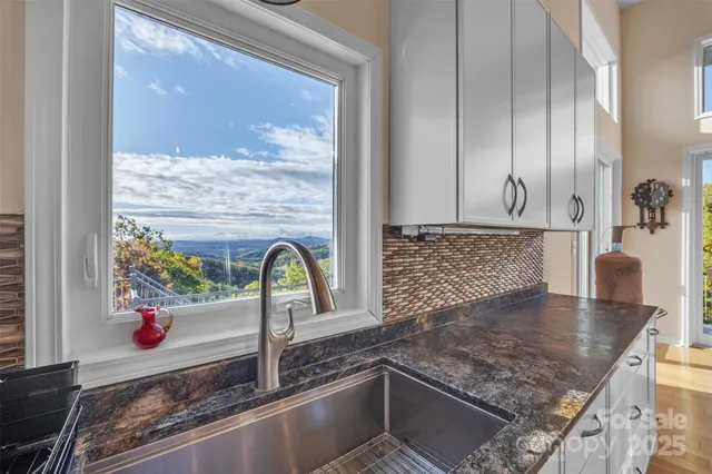 a kitchen with a granite countertop sink and a window