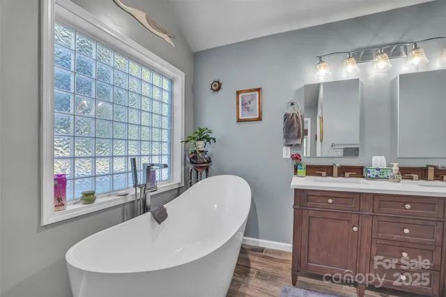 a bathroom with a tub sink and mirror