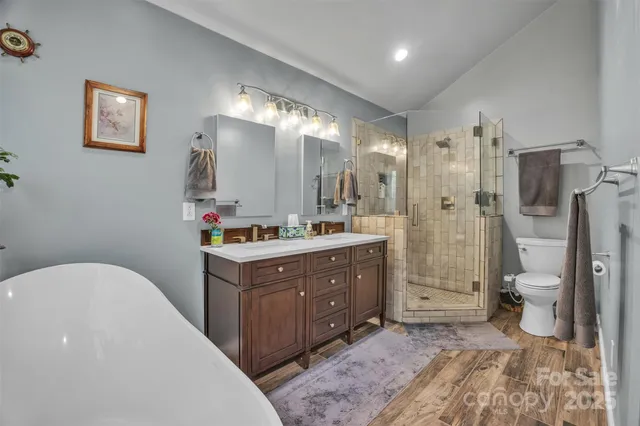 a bathroom with a tub sink mirror and shower