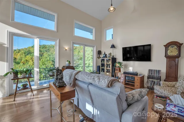 a living room with furniture a flat screen tv and a large window