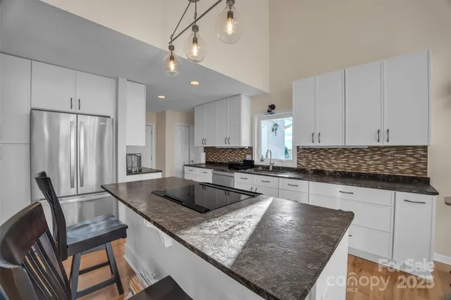 a kitchen with granite countertop a sink a counter top space appliances and cabinets