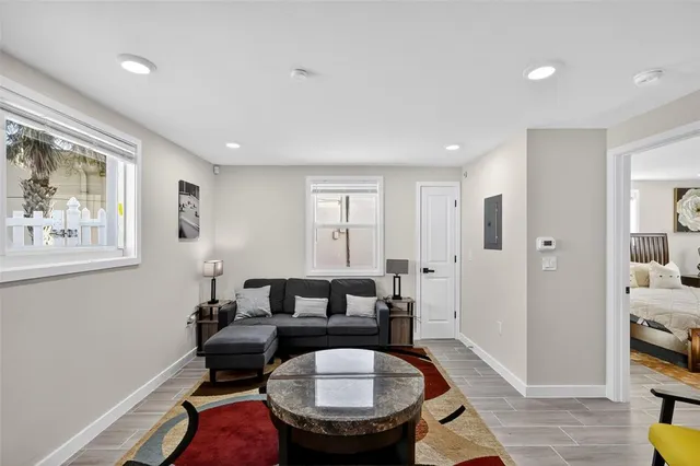 a living room with furniture a window and a potted plant