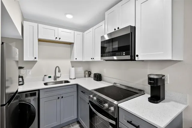a kitchen with a sink stove and cabinets