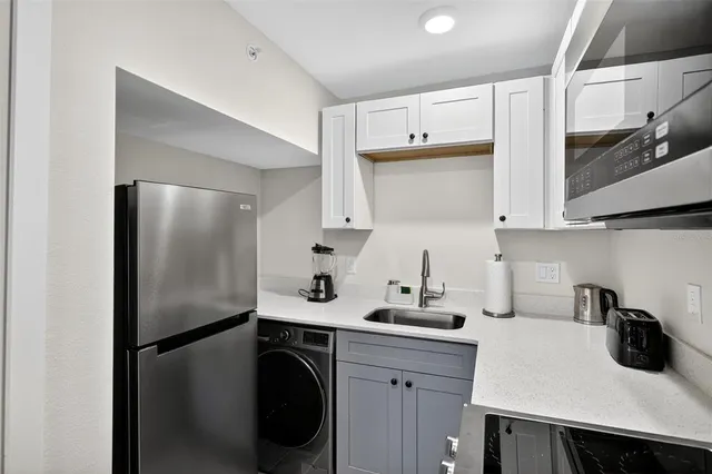 a kitchen with stainless steel appliances a refrigerator a sink and cabinets