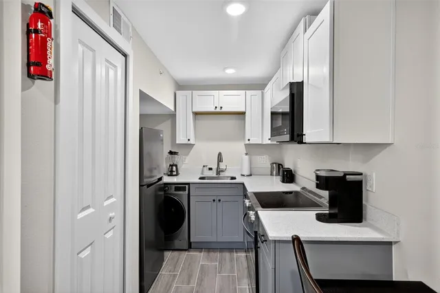 a kitchen with a sink dishwasher a stove and a refrigerator with wooden floor