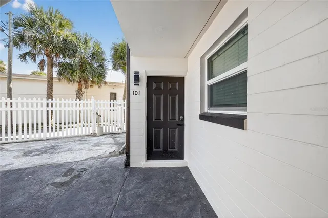 a view of a house with a door and wooden fence