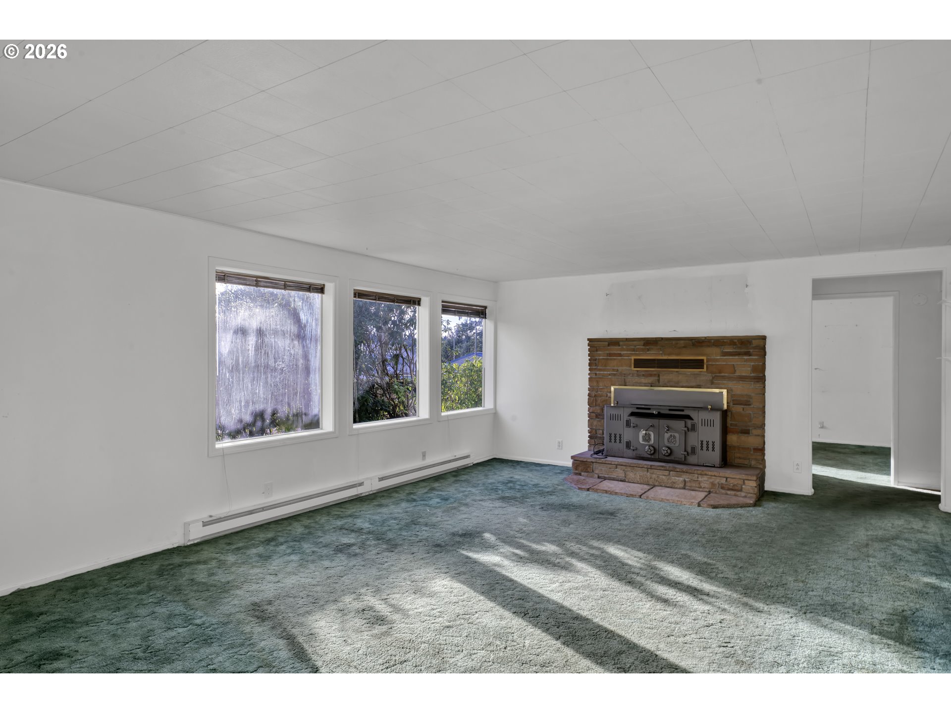 777 Rhododendron Drive Florence, OR 97439 - Photo 8 of 41 a view of an empty room with a window and fireplace