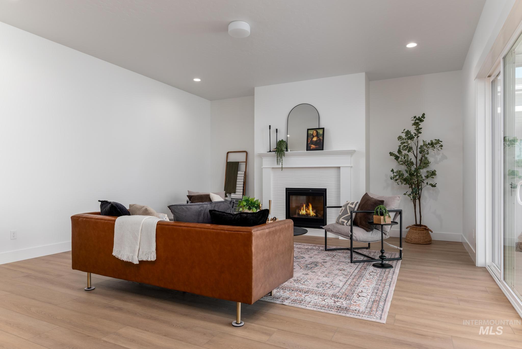 9074 West Moonglade Street Star, ID 83669 - Photo 5 of 40 Living area featuring light wood-finish flooring, recessed lighting, and a white fireplace with a mantel