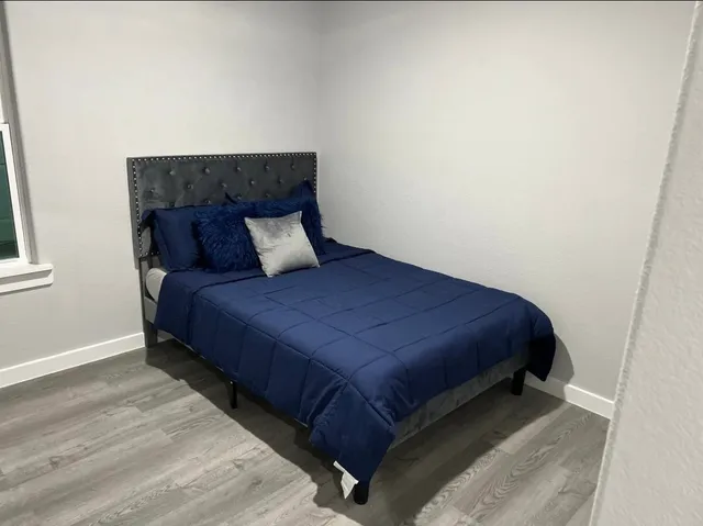 a bed sitting in a bedroom next to a small window