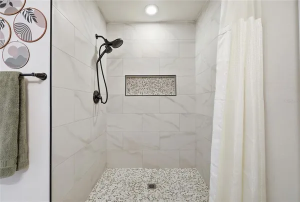 a living room with furniture a ceiling fan and a flat screen tv