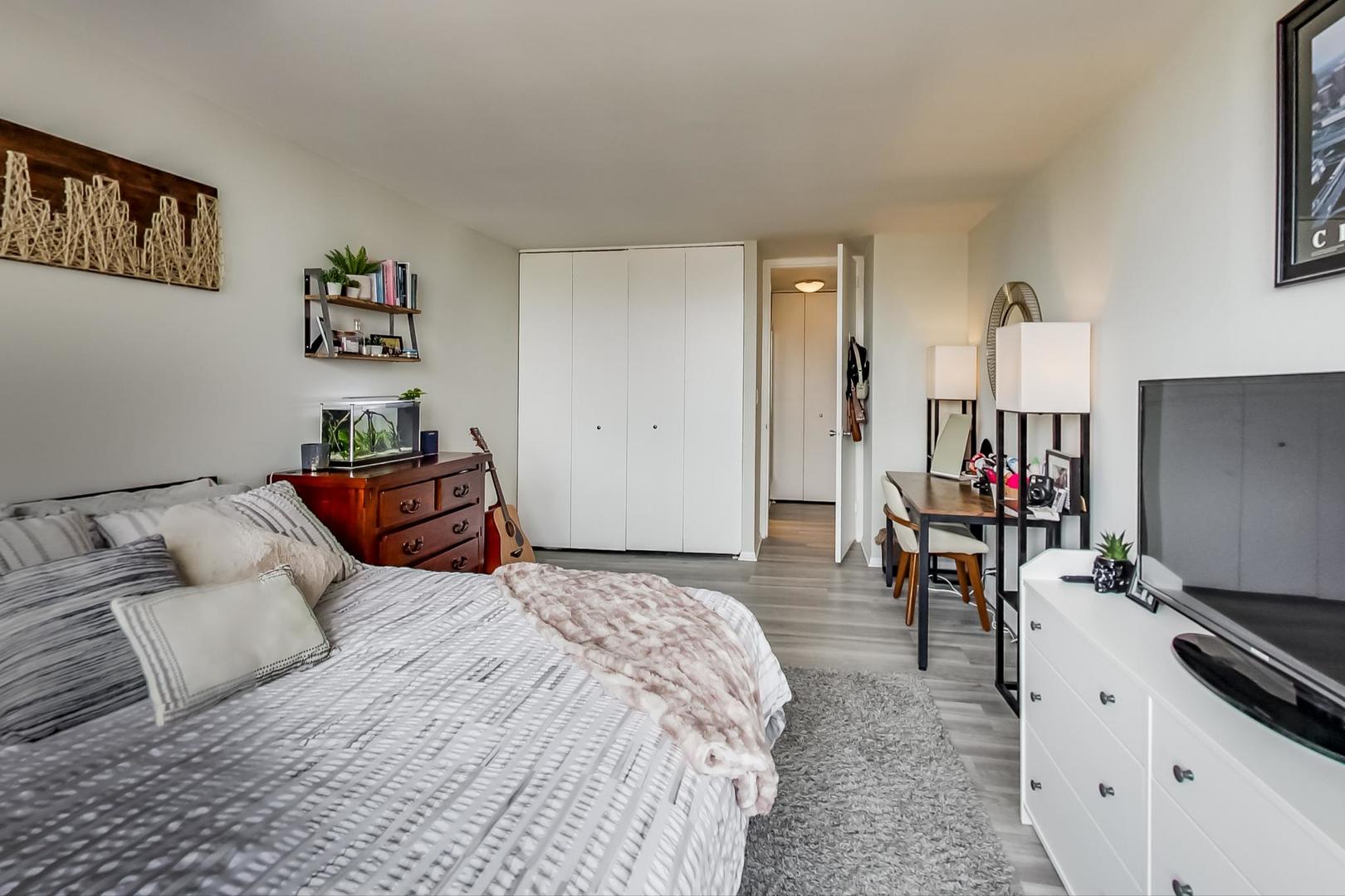 655 West Irving Park Road, Unit 1908 Chicago, IL 60613 - Photo 19 of 29 a bedroom with a bed and a flat tv screen on the dresser