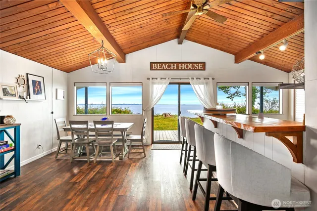 a dining hall with furniture a rug and wooden floor