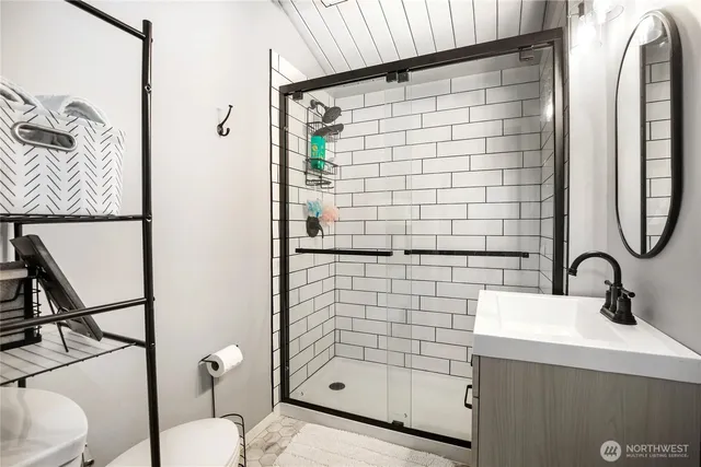 a bathroom with a sink a toilet and shower