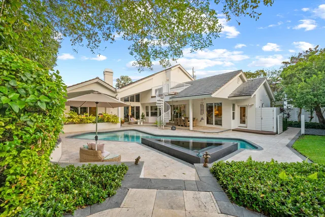 a front view of a house with swimming pool having outdoor seating