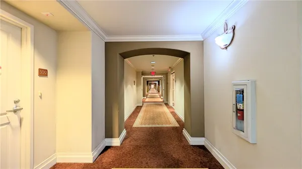 a view of a hallway with wooden floor and a living room