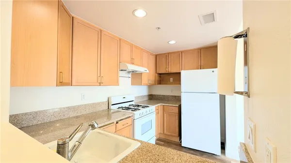 a kitchen with a refrigerator a stove top oven a sink and cabinets