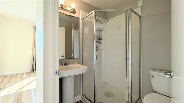 a bathroom with a shower a sink and a toilet