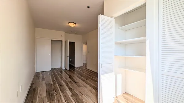 a view of a bedroom with wooden floor and a window