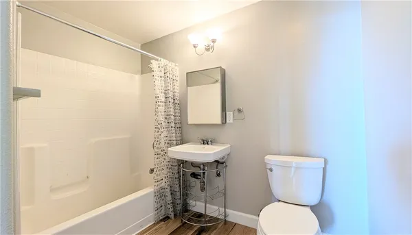 a bathroom with a toilet a sink and mirror