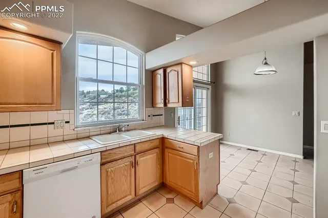 a kitchen with a sink window and cabinets