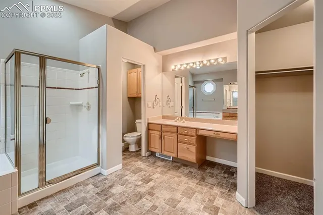 a large bathroom with a glass door shower and sink