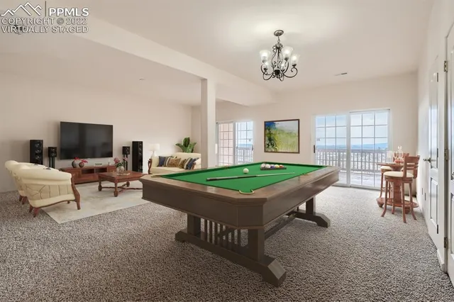 a living room with furniture a chandelier and a flat screen tv