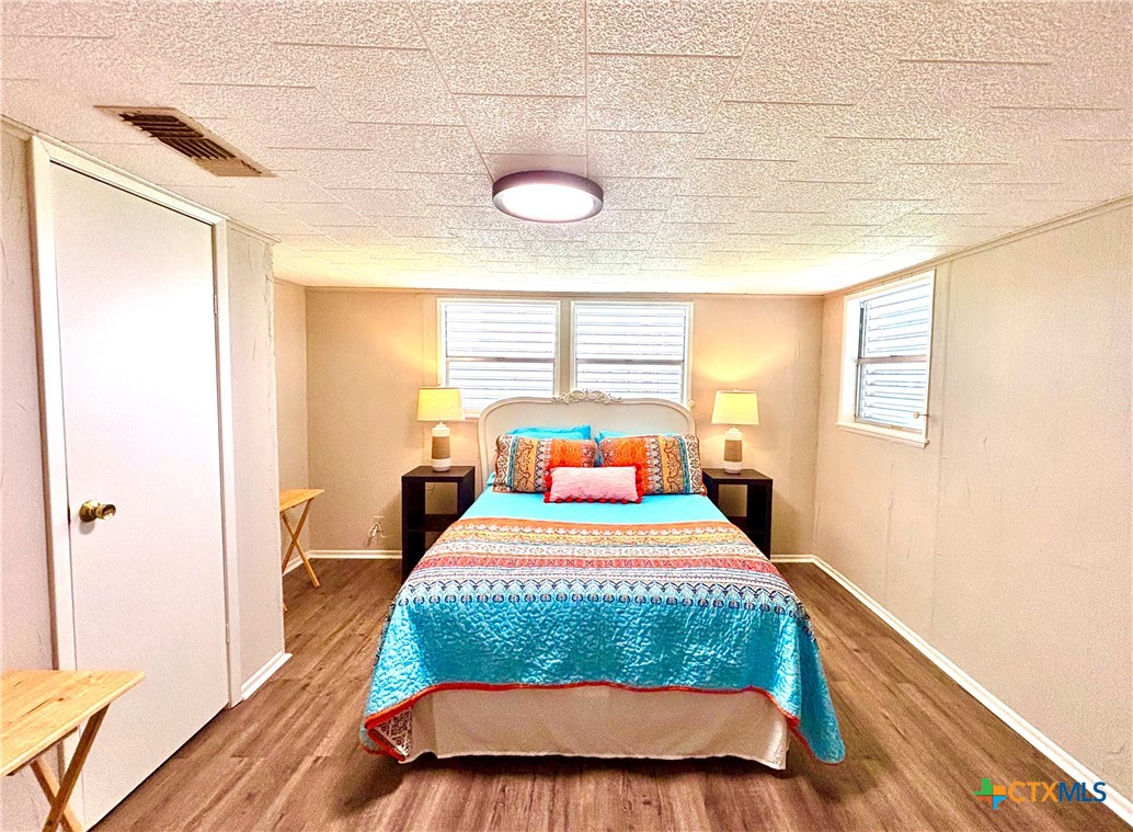 503 16th Street Port O'Connor, TX 77982 - Photo 30 of 48 a bedroom with a bed and wooden floor