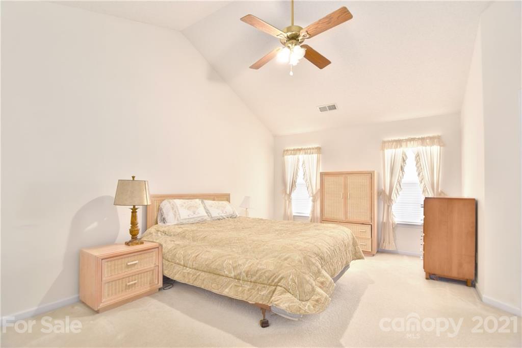 3407 Brownes Ferry Road Charlotte, NC 28269 - Photo 11 of 24 a spacious bedroom with a bed and a chandelier