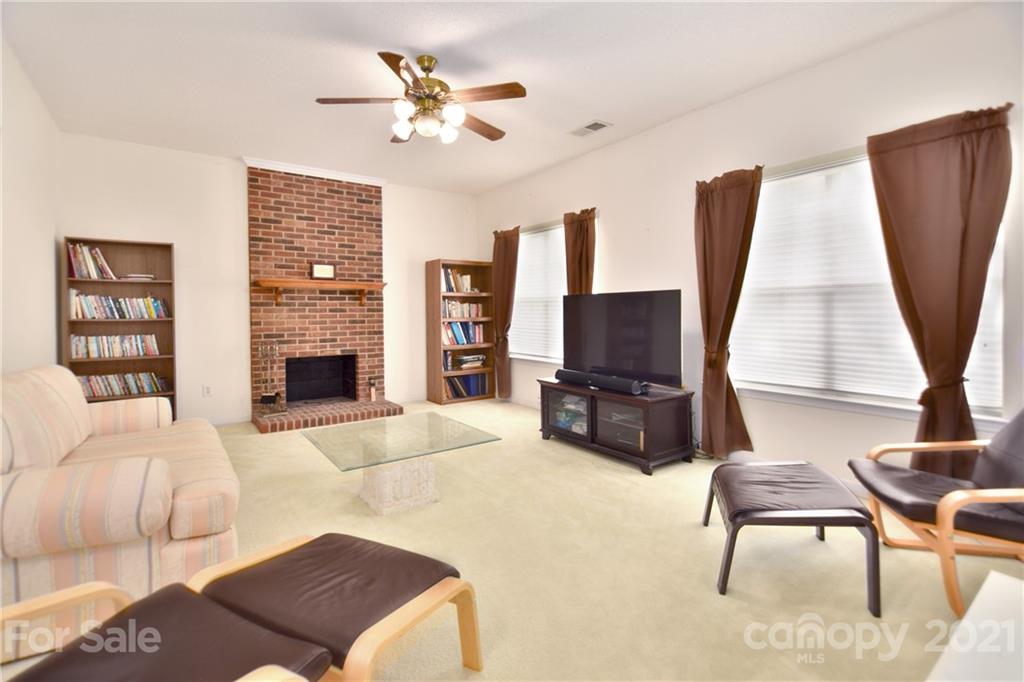 3407 Brownes Ferry Road Charlotte, NC 28269 - Photo 9 of 24 a living room with furniture a fireplace and a flat screen tv