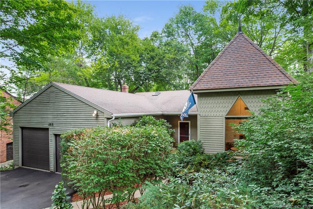 a front view of a house with a yard and trees