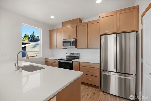 a kitchen with granite countertop a refrigerator stove and sink