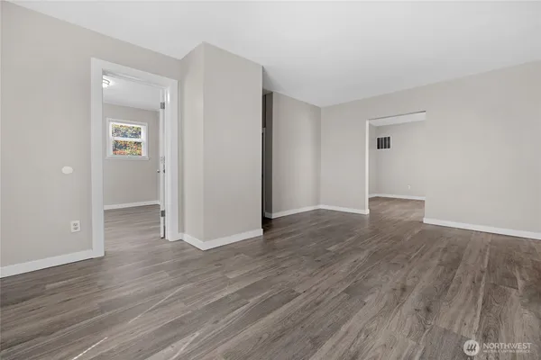 an empty room with wooden floor & closet area