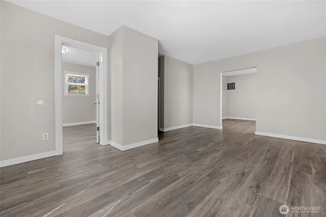 an empty room with wooden floor & closet area