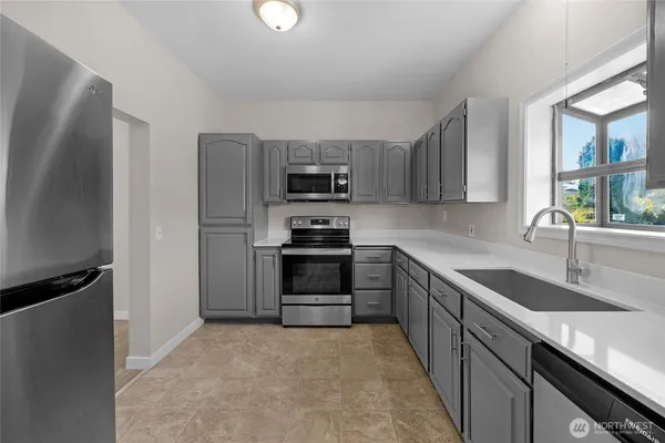 a kitchen with granite countertop a refrigerator stove and sink
