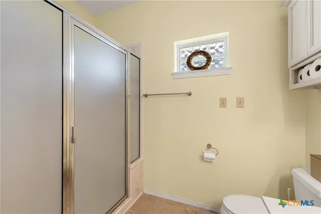 a bathroom with a toilet and a shower curtain