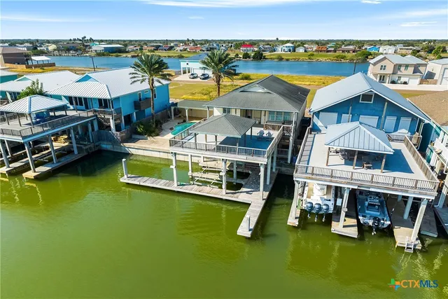 an aerial view of residential houses with outdoor space and swimming pool