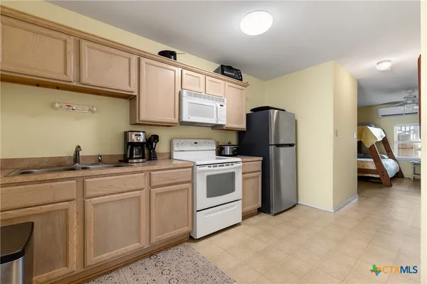 a kitchen with stainless steel appliances granite countertop a sink cabinets and a refrigerator