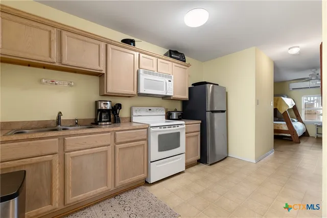 a kitchen with stainless steel appliances granite countertop a sink cabinets and a refrigerator