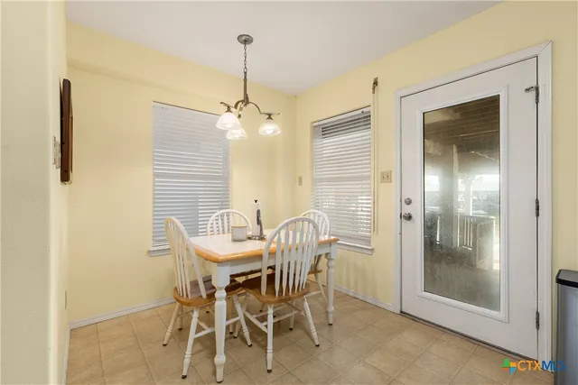 a view of a dining room with furniture and a chandelier