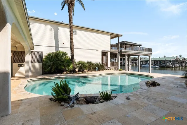 a swimming pool with outdoor seating and a potted plant