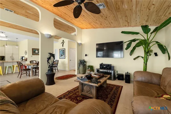 a living room with furniture kitchen view and a large window