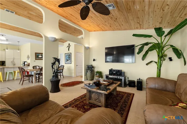 a living room with furniture kitchen view and a large window