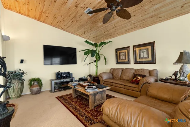 a living room with furniture a chandelier and a flat screen tv