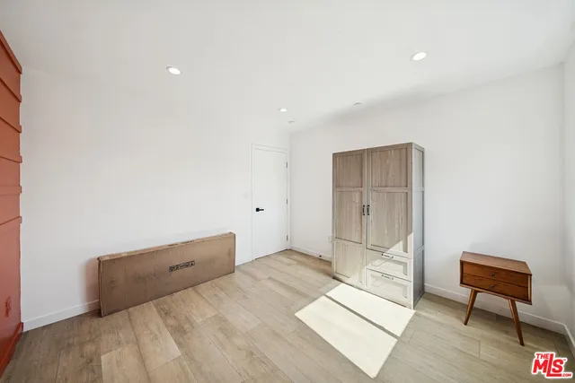 a spacious bedroom with a bed and a chair