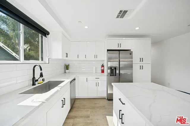 a kitchen with a sink a stove a refrigerator and cabinets