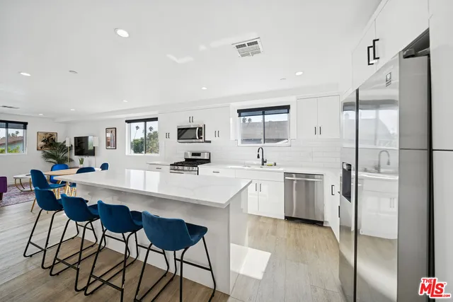 a kitchen with white cabinets and stainless steel appliances