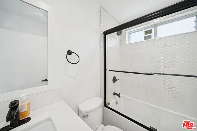 a bathroom with a shower a toilet and a sink