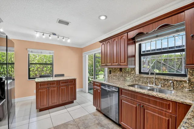 a kitchen with stainless steel appliances granite countertop wooden cabinets a sink and dishwasher