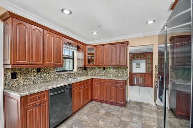 a kitchen with stainless steel appliances granite countertop a refrigerator and a stove top oven